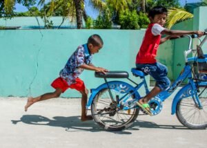 maldivas cultura niños jugando con bicicleta